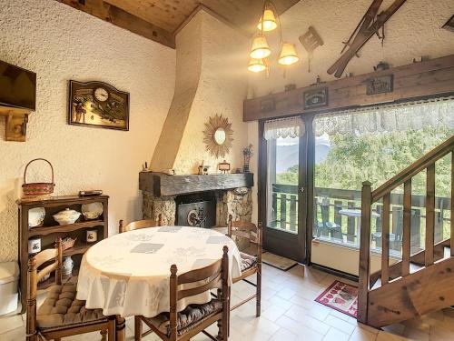 une salle à manger avec une table et une cheminée dans l'établissement Duplex 35m² à 2 pas du centre de Combloux, 4 couchages, balcon, proche pistes - FR-1-560-19, à Combloux