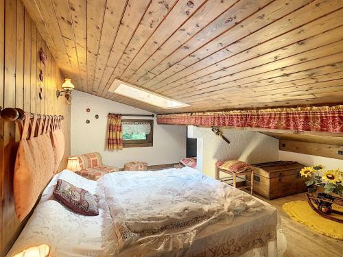 une chambre avec un lit et un plafond en bois dans l'établissement Duplex 35m² à 2 pas du centre de Combloux, 4 couchages, balcon, proche pistes - FR-1-560-19, à Combloux