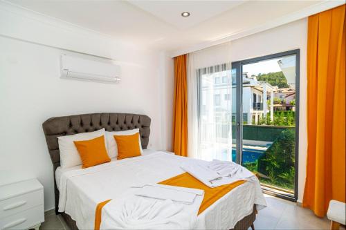 ein Schlafzimmer mit einem Bett und einem großen Fenster in der Unterkunft Hisarönü'de 4 Yatak Odalı Villa-Villa Bahama in Fethiye