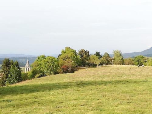 a field of grass with a building in the background at Balcons du Royans.Logement entier Piscine in Saint-Jean-en-Royans