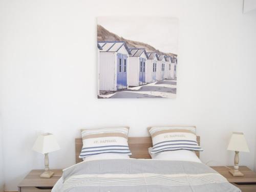 une chambre avec un lit et un tableau au mur dans l'établissement Appartement 2 étoiles, balcon, marché Arago, 350m plage, Les Sables-d'Olonne - FR-1-197-465, à Les Sables-dʼOlonne