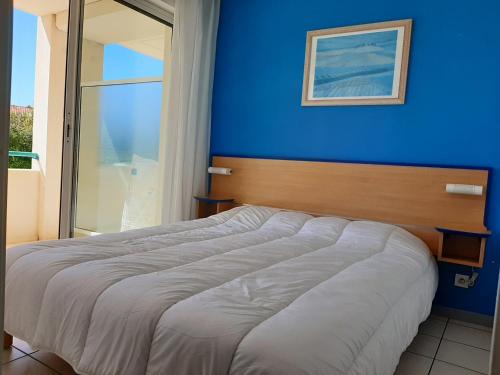 a bedroom with a blue wall and a bed at Appartement Ciboure, 2 pièces, 4 personnes - FR-1-239-551 in Ciboure