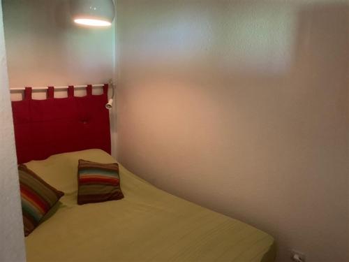 Dormitorio pequeño con cama con cabecero rojo en Appartement Mont-Dore, 2 pièces, 4 personnes - FR-1-415-92, en Le Mont-Dore