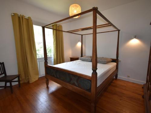 ein Himmelbett in einem Schlafzimmer mit Holzboden in der Unterkunft Villa Pyla-sur-Mer, 5 pièces, 9 personnes - FR-1-420-94 in La Teste-de-Buch