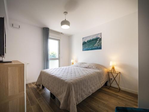 een witte slaapkamer met een bed en een raam bij Appartement Saint-Jean-de-Luz, 2 pièces, 4 personnes - FR-1-239-522 in Saint-Jean-de-Luz
