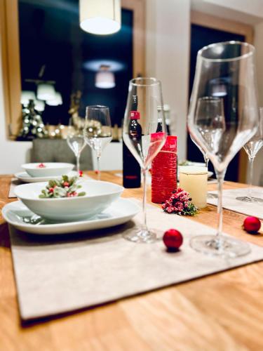 a table with wine glasses and a plate of food at AmStein in Kaltenbach
