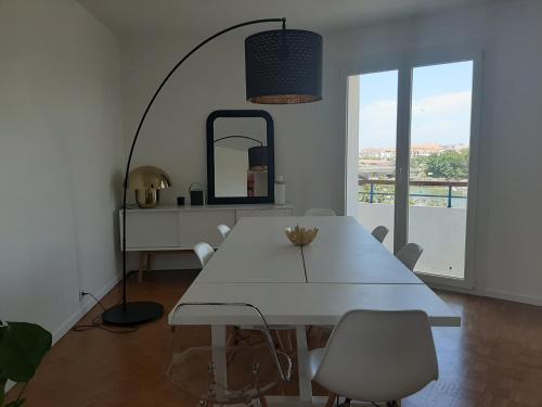 ein weißes Esszimmer mit einem weißen Tisch und Stühlen in der Unterkunft Appartement Ciboure, 4 pièces, 6 personnes - FR-1-239-554 in Ciboure