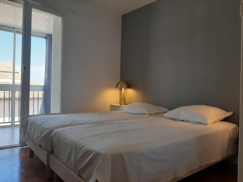 1 dormitorio con 1 cama blanca grande y ventana en Appartement Ciboure, 4 pièces, 6 personnes - FR-1-239-554, en Ciboure