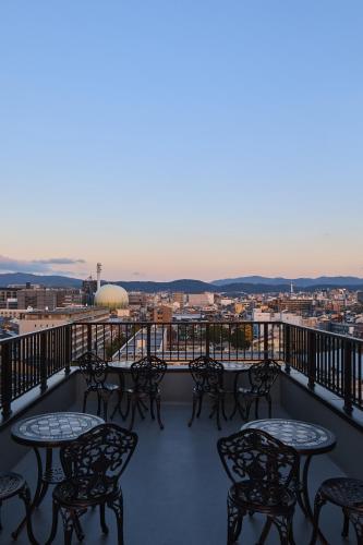 a balcony with tables and chairs and a view at Sekia Wagaya Hotel in Karahashi Rashomon