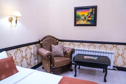 a room with a bed and a chair and a table at Belon Lux Hotel in Astana