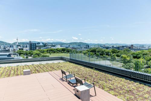 a balcony with two benches and a view of the city at Umekoji Potel KYOTO in Kyoto