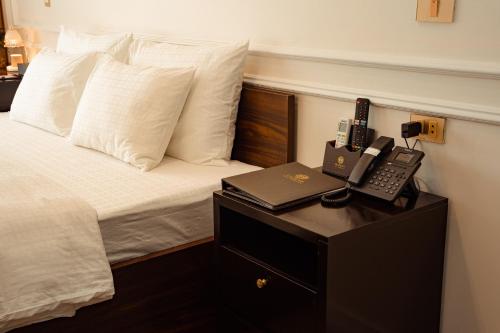 a hotel room with a bed with a phone on a table at Dolce Mia Home Ninh Bình in Ninh Binh
