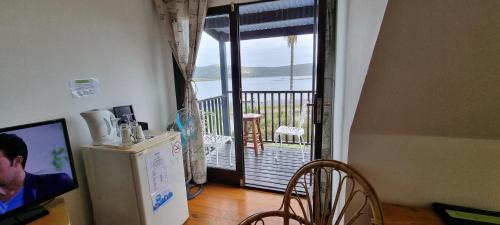 a kitchen with a refrigerator and a door to a balcony at Lagoon Lodge in Knysna