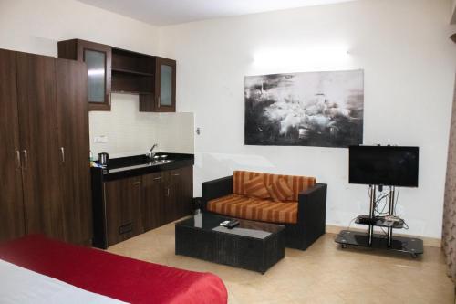 sala de estar con sofá, lavabo y TV en Royale Assagao Resort, en Assagao