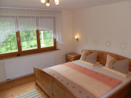 sypialnia z dużym drewnianym łóżkiem i oknem w obiekcie Haus Post OG-Wohnung w mieście Todtnau