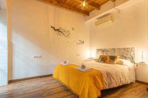 - une chambre avec un grand lit et une couverture jaune dans l'établissement APARTAMENTO PATIO ANDALUZ EN SEVILLA, à Séville