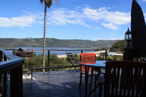a patio with a table and chairs and a view of the water at Lagoon Lodge in Knysna