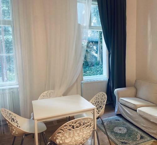 sala de estar con mesa, sillas y sofá en Milos Apartment en Viena