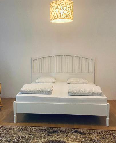 a white bed with two pillows on it in a room at Milos Apartment in Vienna