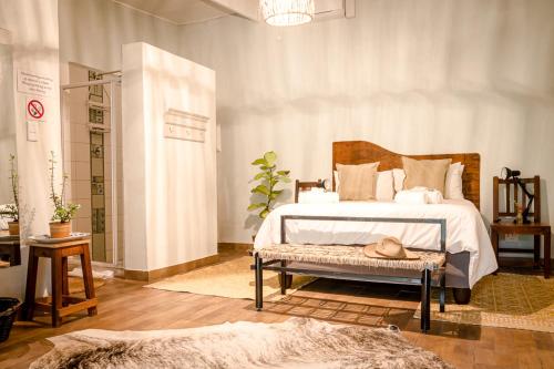 ein Schlafzimmer mit einem Bett mit einem Hut auf einer Bank in der Unterkunft Francines Venue Pty Ltd in Hoedspruit