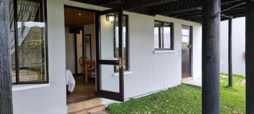 a front door of a house with a grass yard at Lagoon Lodge in Knysna