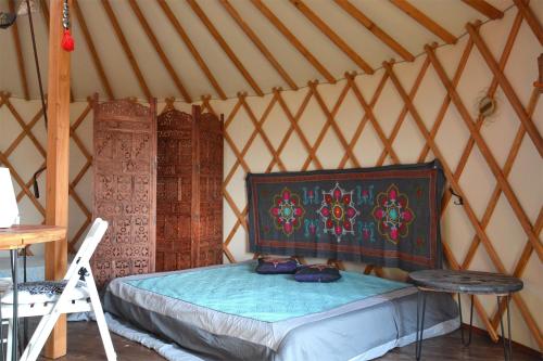 Łebki的住宿－Dzika Jurta na Łebkach，蒙古包内的卧室,配有床和梯子