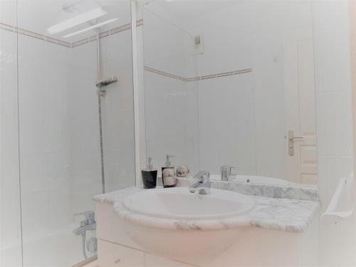 y baño blanco con lavabo y ducha. en Appartement Ciboure, 2 pièces, 4 personnes - FR-1-239-511 en Ciboure