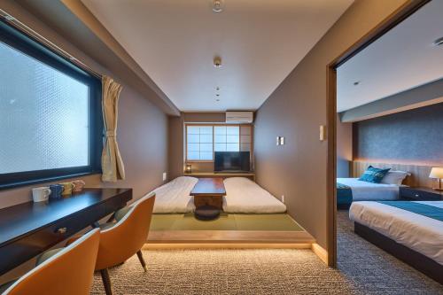 a bedroom with two beds and a large window at Sekia Wagaya Hotel in Karahashi Rashomon