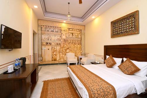 ein Hotelzimmer mit einem Bett und einem Tisch und Stühlen in der Unterkunft Aaram Baagh Maheshwar in Maheshwar