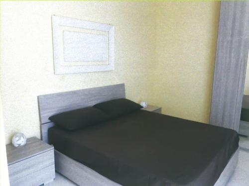 a bedroom with a bed with a black comforter at Casa Airone in SantʼAlessio Siculo