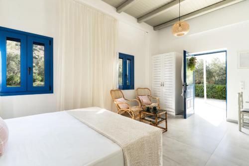 a bedroom with a bed and two chairs in it at Alasthas in Gavrio