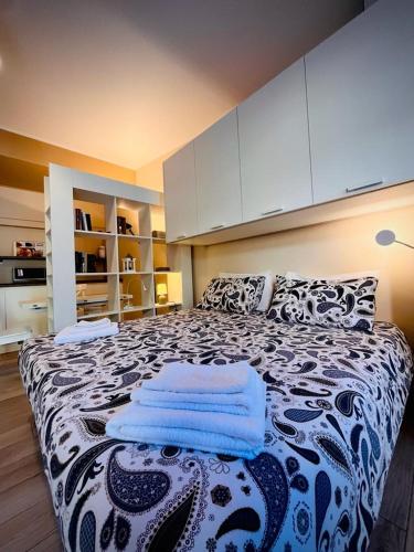 a bedroom with a large bed with towels on it at BelSorrisoVarese - Elegance City Residence Private Parking -Reservation Required- in Varese