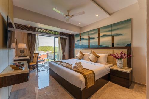 a bedroom with a large bed and a balcony at Regenta Central Imperial Candolim Goa in Candolim