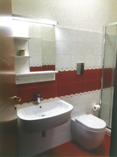 a bathroom with a white sink and a toilet at Casa Airone in SantʼAlessio Siculo