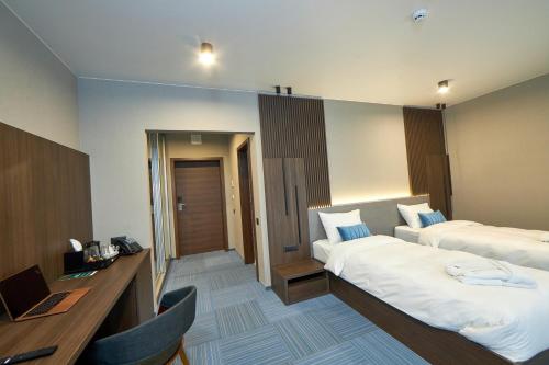 a hotel room with two beds and a desk at Спа-готель ПОЛО-МЕДЛАЙФ in Kremenchuk