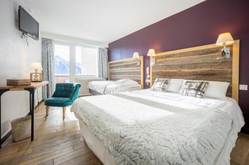 a hotel room with two beds and a television at Le Christiania in Saint-Lary-Soulan