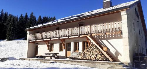 a building with a pile of fire wood in front of it at Gîtes Tré Le Grenier in Les Moussières