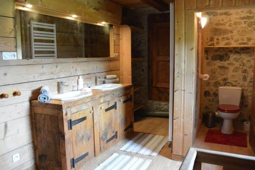 a bathroom with two sinks and a toilet at Gîtes Tré Le Grenier in Les Moussières