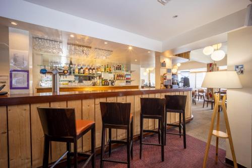 a bar with four chairs and a counter at Le Christiania in Saint-Lary-Soulan