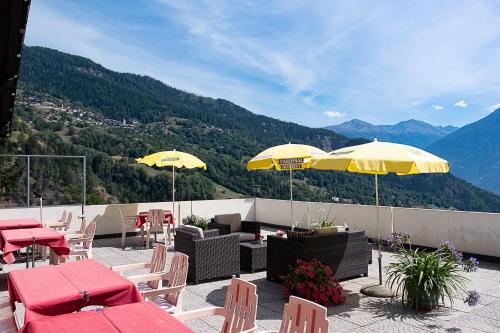 a patio with tables and chairs and umbrellas at B&B Pension Rustica in Inden