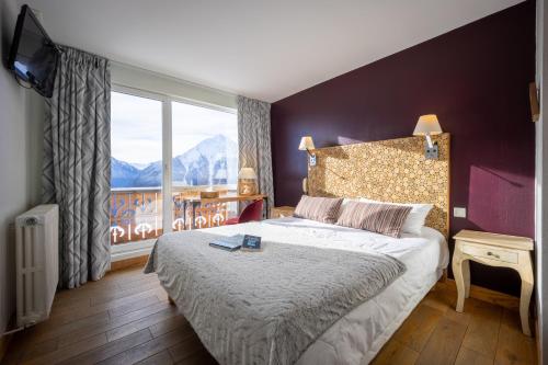 a bedroom with a bed and a large window at Le Christiania in Saint-Lary-Soulan
