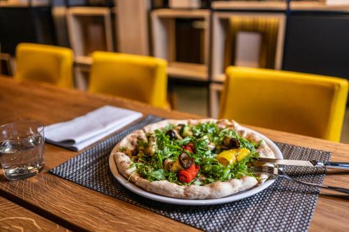 a pizza on a plate on a table at Hotel Krone - Aktiv & Erholt in Churwalden