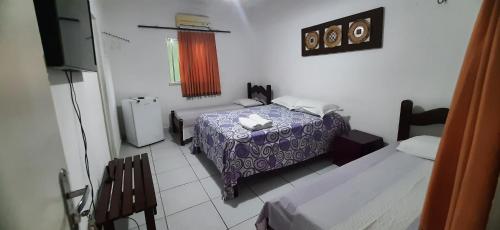 מיטה או מיטות בחדר ב-Pousada Casa da Lucinha