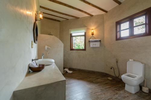 a bathroom with a sink and a toilet and a window at Emburara Farm Lodge in Mbarara