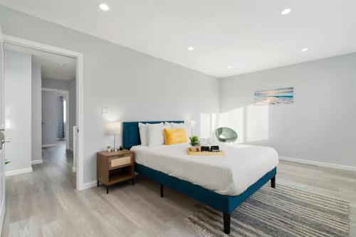Un dormitorio con una cama azul y blanca y una mesa en Beautiful Vacation Home in Pacifica near popular beaches en Pacifica