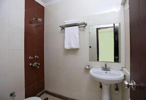 a bathroom with a sink and a mirror and a toilet at Hotel Aero link Ltd in Dhaka