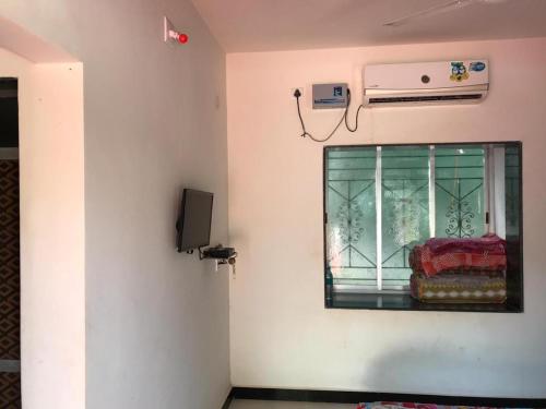 Cette chambre dispose d'une fenêtre avec une chaise. dans l'établissement Acharekar's Home stay - Adorable AC and Non AC Rooms with free Wi-Fi, à Malvan