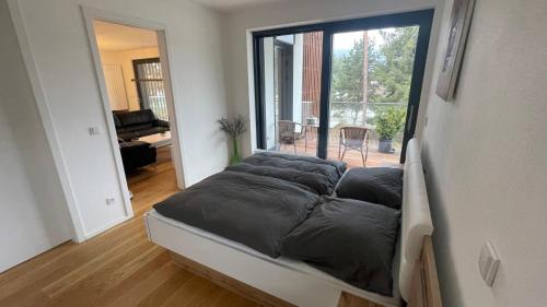 a bed in a room with a large window at Lipno A1 in Lipno nad Vltavou