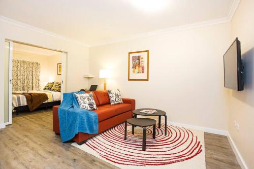 a living room with a couch and a bed at Perth City Living 105 in Perth