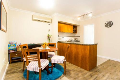 a kitchen and dining room with a table and chairs at Perth City Living 105 in Perth